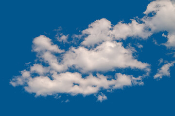White cumulus clouds. A group of clouds on a blue windy sky. Natural sky background.