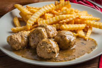 Meatballs with french fries in dill sauce.