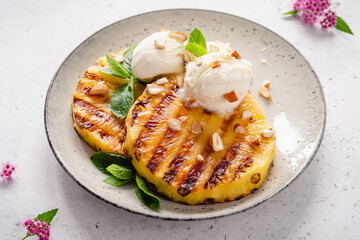 Grilled pineapple with scoops of vanilla ice cream