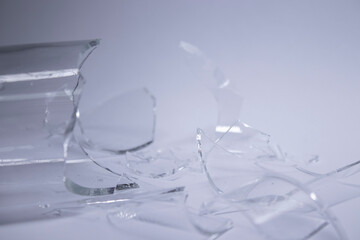 pieces of broken glass are scattered on a gray-white background. High quality photo