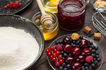 Flour and berries. Jar of honey and jam.