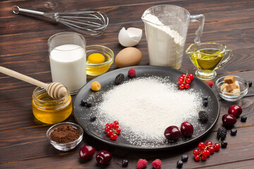 Ingredients for baking berry pie. Flour in black plate