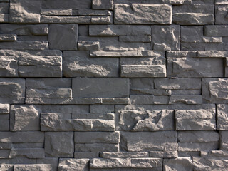 Texture of a black slate bricks creating a stylish wall on a building
