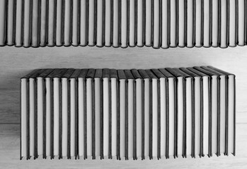 books in two rows, make elegant shape, black and white, wooden background, top view