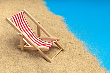Fototapeta na wymiar Beach chairs on pastel blue background. Summer vacation, travel. Miniature chair.