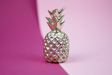 Golden pineapple with stylish decor on colorful background. Silver and gold home decorations. Copy space.