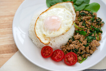 Homemade Stir fried minced pork with basil served with steamed jasmin rice and fired egg, Thai famous spicy food, Thai name is Pad kra pao Kai dow