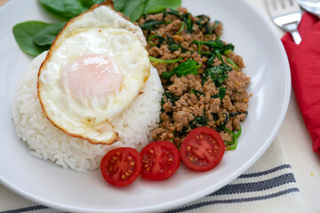 Homemade Stir fried minced pork with basil served with steamed jasmin rice and fired egg, Thai famous spicy food, Thai name is Pad kra pao Kai dow