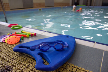 Blue swimming boards with swimming glasses and toys of the pool