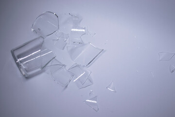 pieces of broken glass are scattered on a gray-white background. High quality photo
