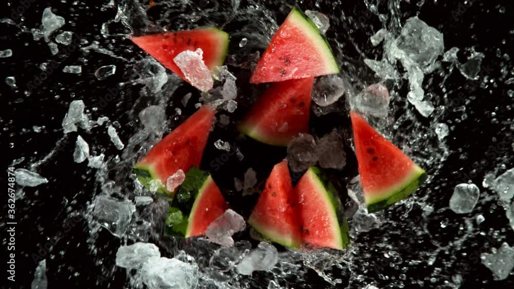 Poster super slow motion of melon slices with ice rotating in water, black background. filmed on high speed