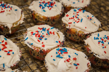 Homemade Patriotic Cupcakes with Sprinkles Sitting on Drying Rack