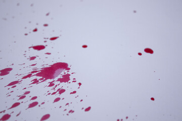 drops of red liquid - blood - on a white paper. Copy space. High quality photo