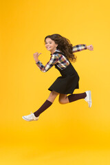 Fototapeta na wymiar Break into. Feel inner energy. Girl with long hair jumping on yellow background. Carefree kid summer holiday. Time for fun. Active girl feel freedom. Fun and jump. Happy childrens day. Jump concept