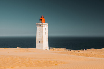 Fototapeta na wymiar Famous historic light house in the middle of the largest sand dunes in europe. Must seen places during summer vacation. Rubjerg, Knude, North Sea, North Jutland, Denmark, Scandinavia in Europe