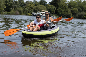 MAN AND WOMAN KAYAKING IN RIVER