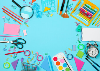 Back to school shopping concept. School supplies on blue background. Flat lay, top view, copy space.