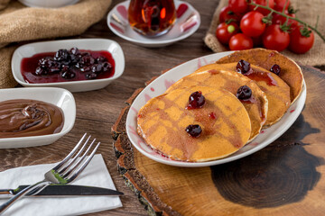 Chocolate pancake with chocolate glaze and sour cherry. Selective focus