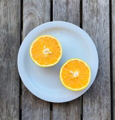 Orange slices on a white plate, on a wood table