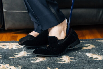 A man puts on shoes with a Shoe spoon