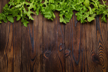 Fresh farm arugula on a brown wooden background