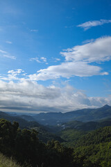 Blue sunny landscape with some mountain clouds covering mountain peak in Montseny, Catalonia