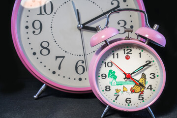 Large and small table top classic analog Clock. On black background