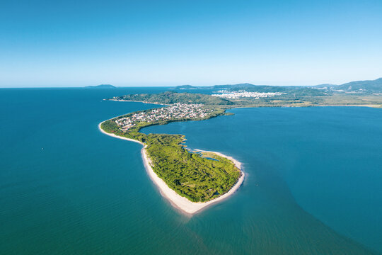 Brazil, Florianopolis. Panoramic aerial view of Daniela beach pontal peninsula and river showing sea, sand, trees and an the village.