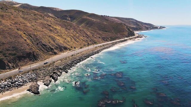 Drone shot of ocean along pacific highway in California on a sunny day