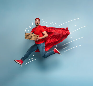 Deliveryman with pizzas acts like a powerful superhero. Concept of success and guarantee on shipment. Studio cyan background