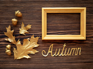 Golden autumn. Oak leaves and acorns on a wooden background. Text frame