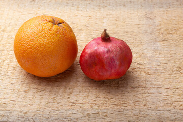 Fresh red pomegranate and grapefruit On a wooden background.