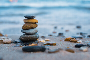 Pebbles are piled on a volcanic rock by the sea. Zen concept. Copy space