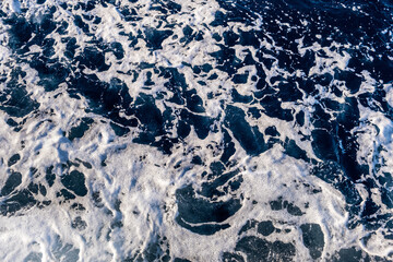 Top down aerial view of sea water surface. White foam waves texture as natural background.