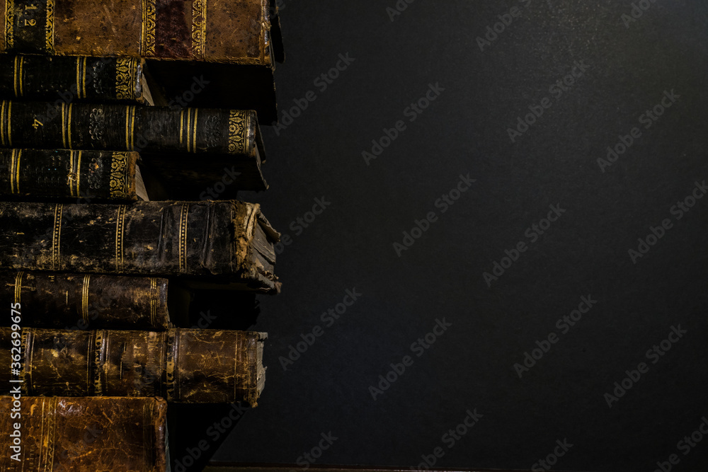 Poster pile of old books on the left side of the image leaving space on the right side for copyspace