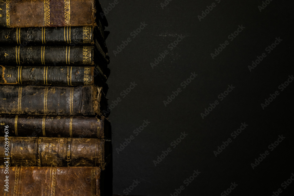 Poster pile of old books on the left side of the image leaving space on the right side for copyspace