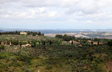 Fototapeta na wymiar Beautiful scenery looking across Tuscany featuring vineyards, buildings, farms