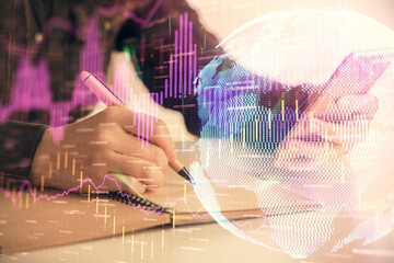 Double exposure of forex graph sketch hologram and woman holding and using a mobile device. Stock market concept.