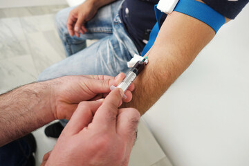 Nurse hands while taking patient blood for analysis in ambulance.