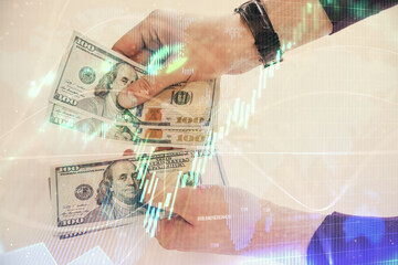 Multi exposure of financial graph drawing hologram and USA dollars bills and man hands. Analysis concept.
