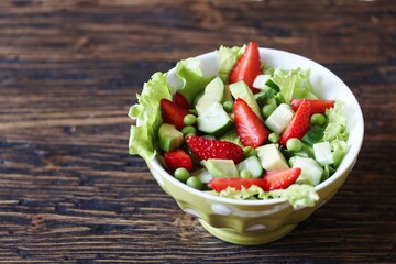 summer salad with strawberries, avocado,   green peas. copy space