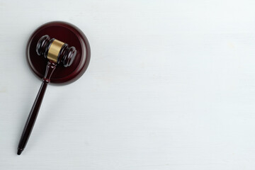 Judge hammer on a white wooden background with copy space and a top view