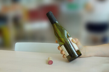 Woman's hand holds a bottle while pouring wine