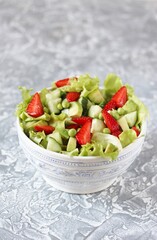 summer salad with strawberries, avocado, cucumber, green peas. copy space