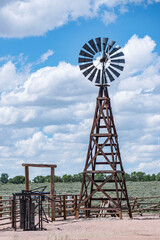 Wooden windmill at corral in pasture to pump water and electricity in Wyoming USA