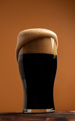 Overflowing stout in a shapely pint glass 