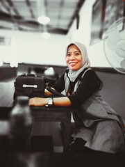 Fototapeta na wymiar Smiling Mature Woman Wearing Hijab While Sitting At Restaurant