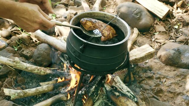 Cooking Fish in Pot on Campfire