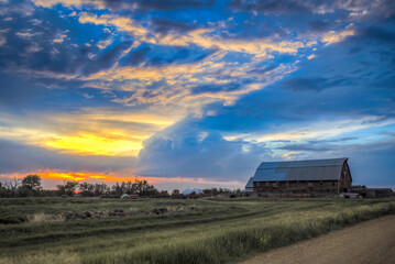 The setting sun illuminates  old, abandoned structures on the Great Plains