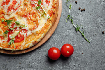 Pizza Margherita on black stone background, top view. Pizza Margarita with Tomatoes, Basil and Mozzarella Cheese close up